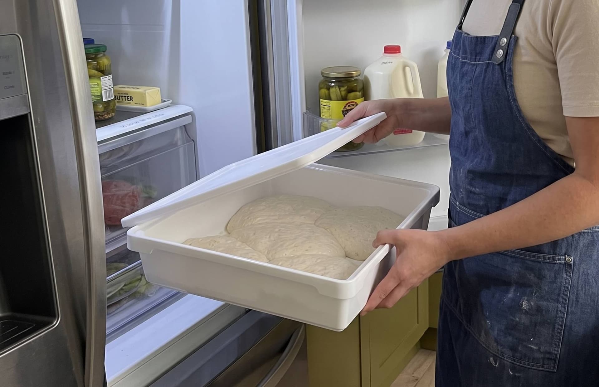Person taking over-proofed dough out of a refrigerator